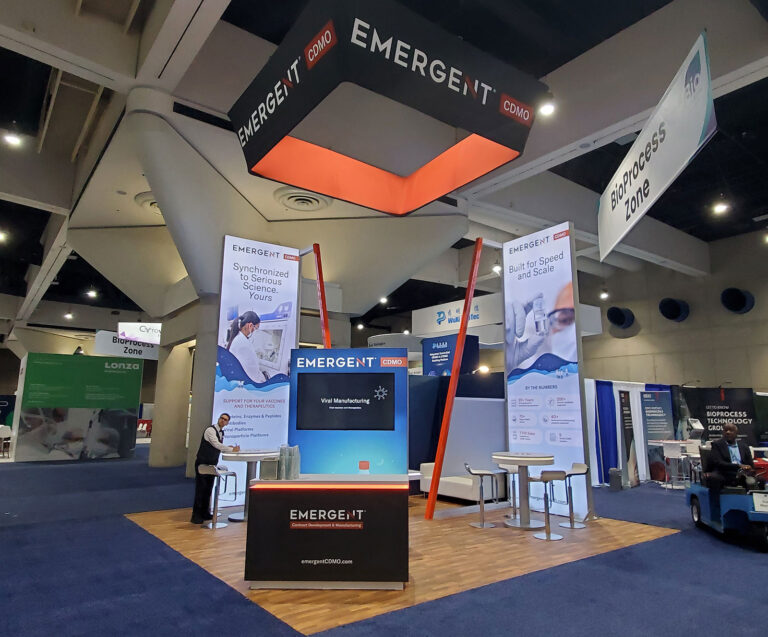 20x20 island booth with custom LED towers and wood vinyl flooring