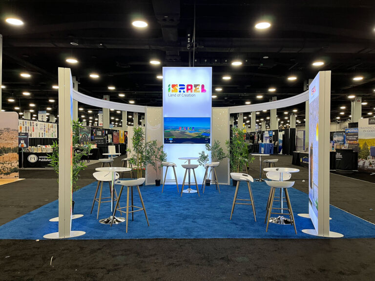 20x20 island trade show exhibit with LED towers and event furniture